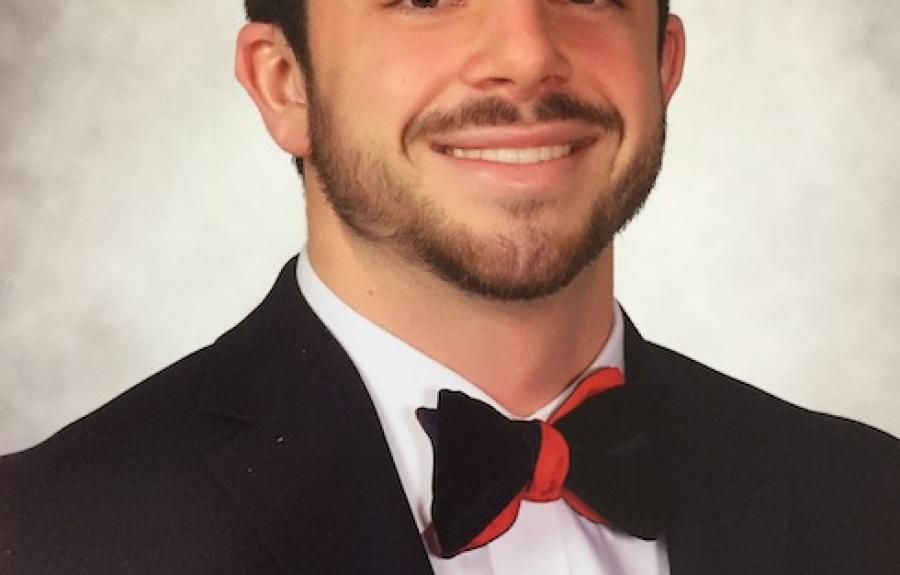student Terence Burke smiling in suit and red bowtie 