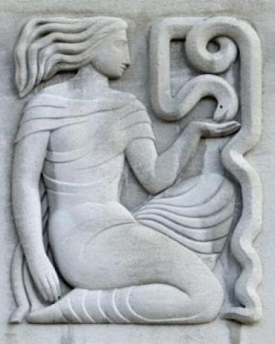 A stone engraving of a woman holding a snake