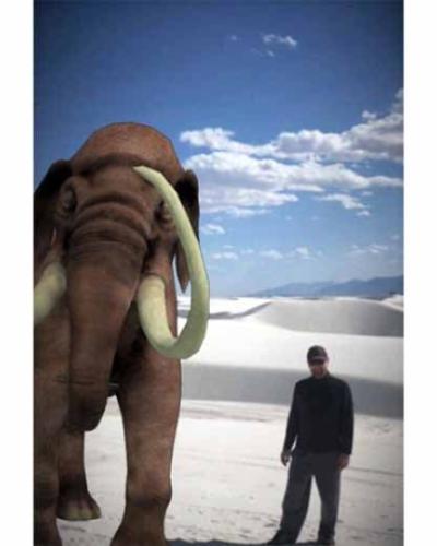 A man poses next to a digital rendering of a wooly mammoth