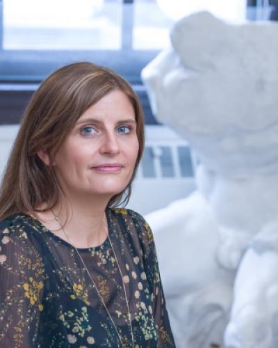 Verity Platt in her office in front of statue.